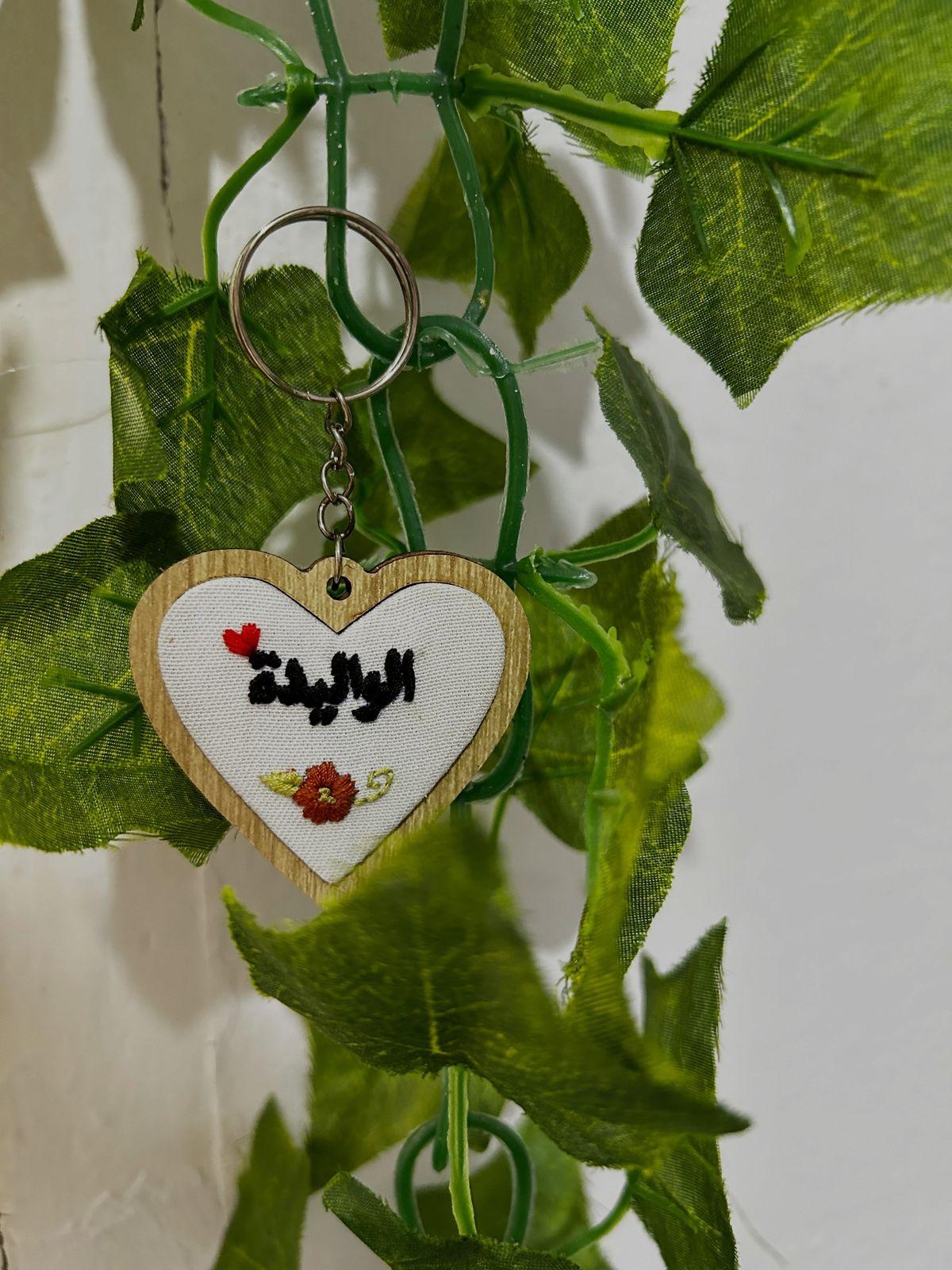 Porte-clés cœur en bois brodé du mot Al Walida et d'une rose rouge